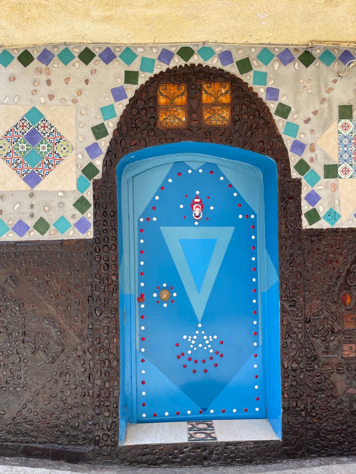 La porta blu della Casbah di Mazara del Vallo, dentro una cornice di mosaico