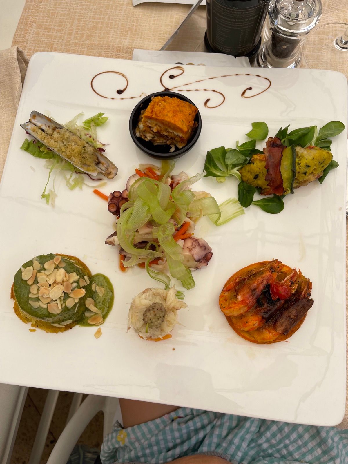 Un piatto con antipasti di mare diversi, uno accanto all’altro
