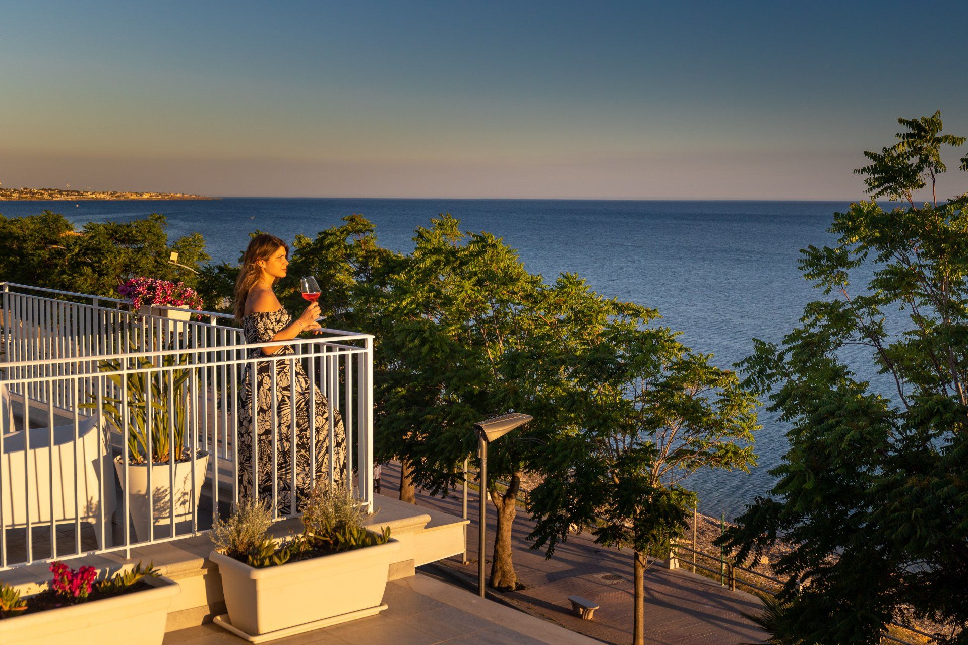 Un calice al parapetto mentre la luce cambia — terrazza condivisa, Mazara del Vallo